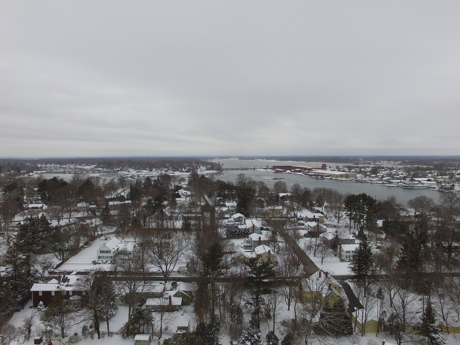 Aerial view of a snow-covered residential neighborhood in Barrington, Rhode Island, with the Barrington River